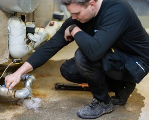 VVS mand arbejder med VVS installation ved gulv