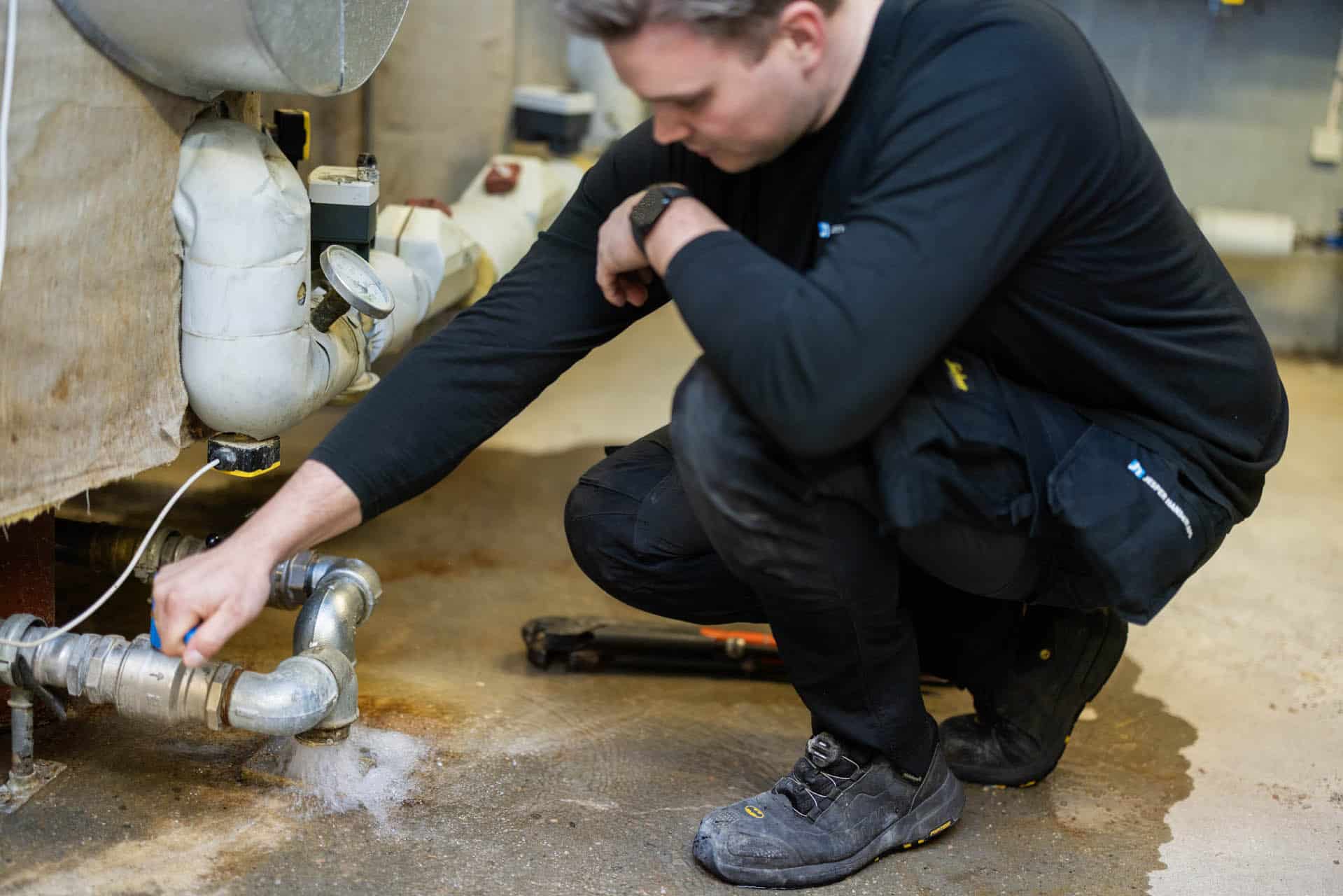 VVS mand arbejder med VVS installation ved gulv